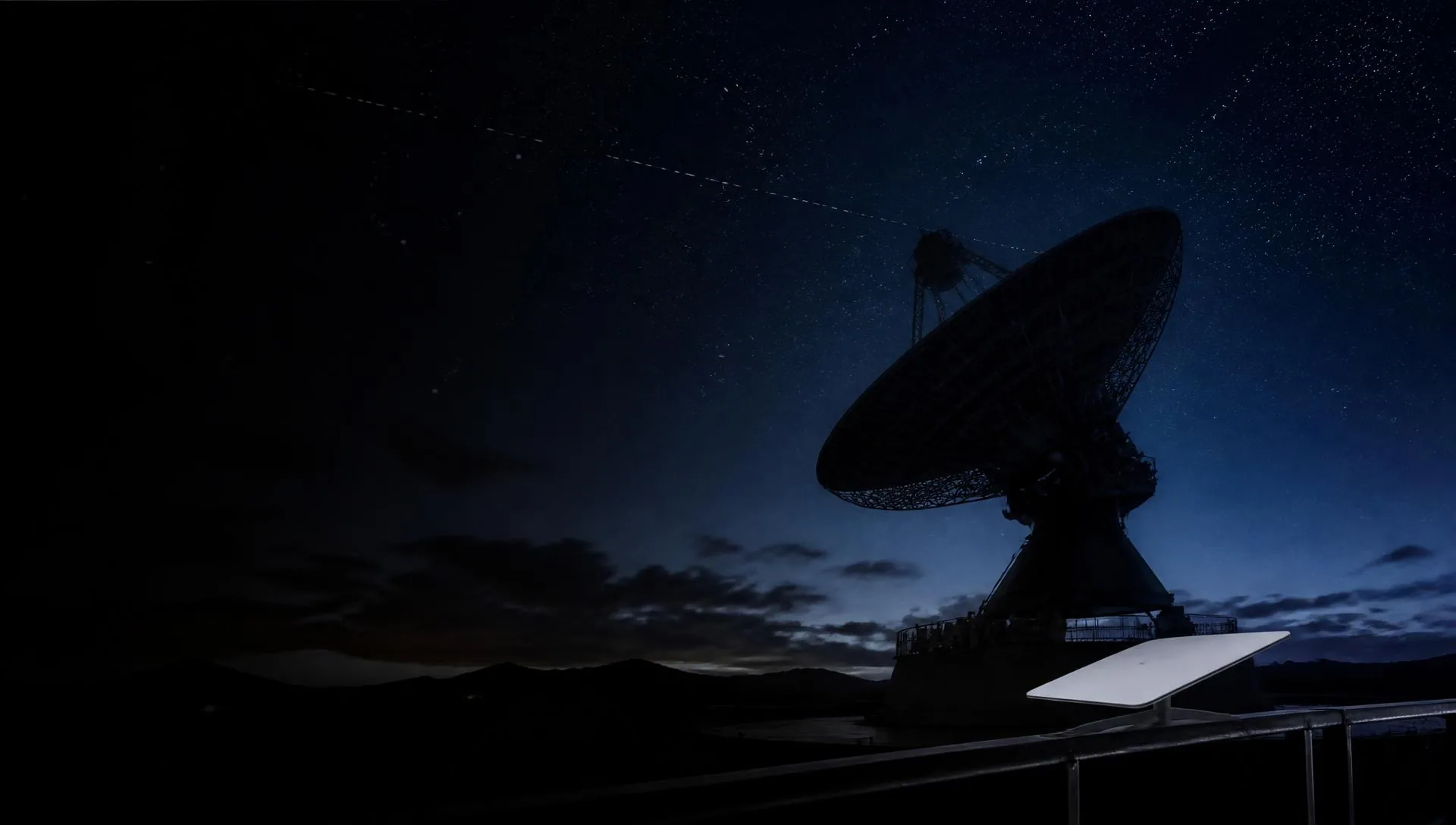 Ground station dish pointed at the starry night sky